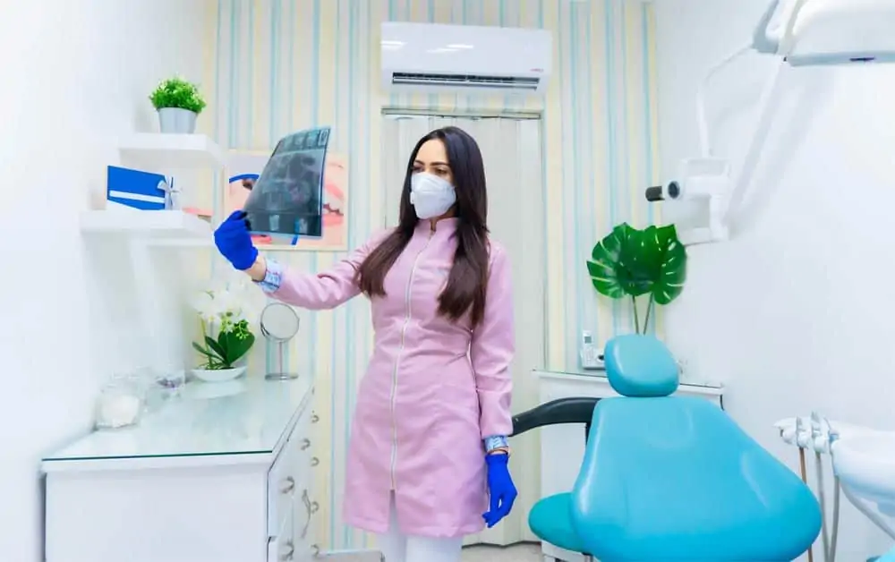 Dentist cleaning her own examination suite -- such a time loss!