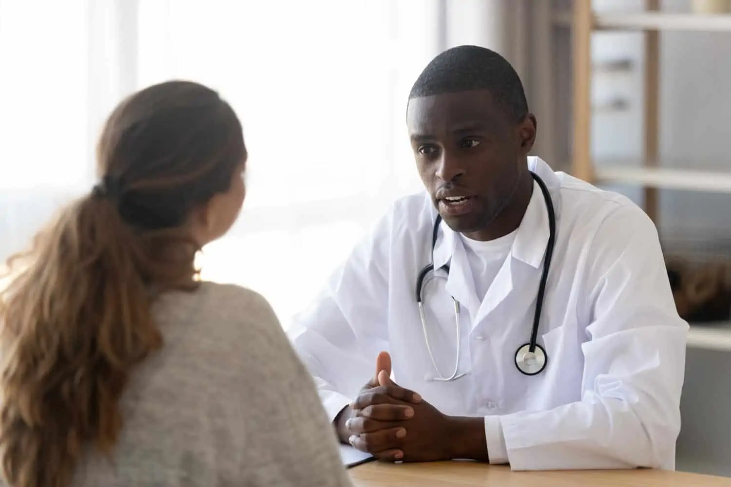 Doctor speaking face to face with a patient. EMR integration companies streamline documentation so that physicians and clinicians spend more time engaging their patients.