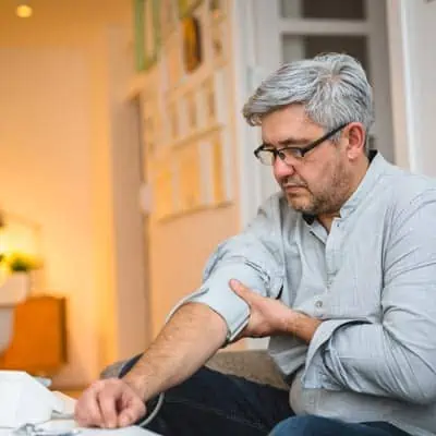 Patient taking blood pressure at home. Better patient engagement leads to better patient compliance.