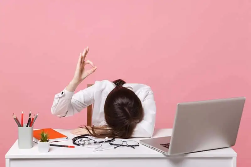 Doctor giving the okay sign, even though she's overwhelmed with medical documentation tasks.