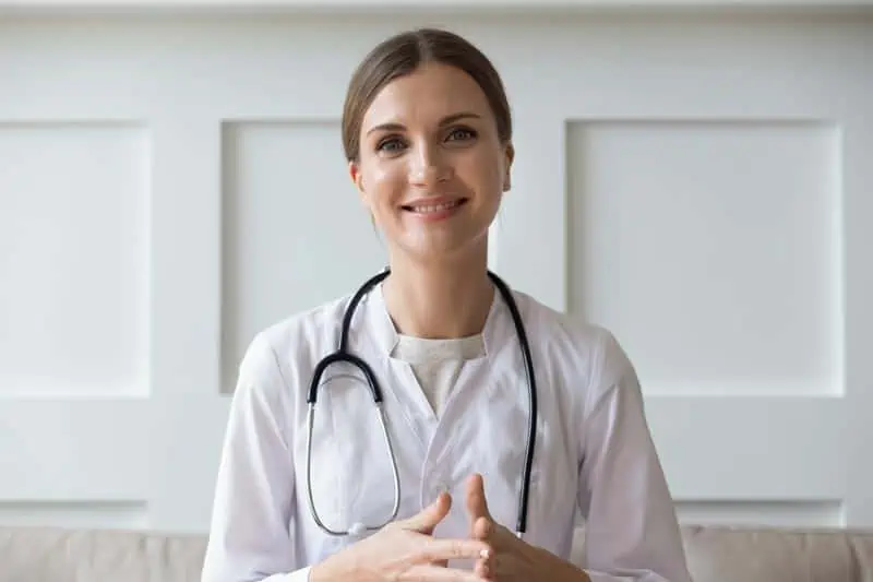 Smiling doctor, happy she has medical documentation services to support her.